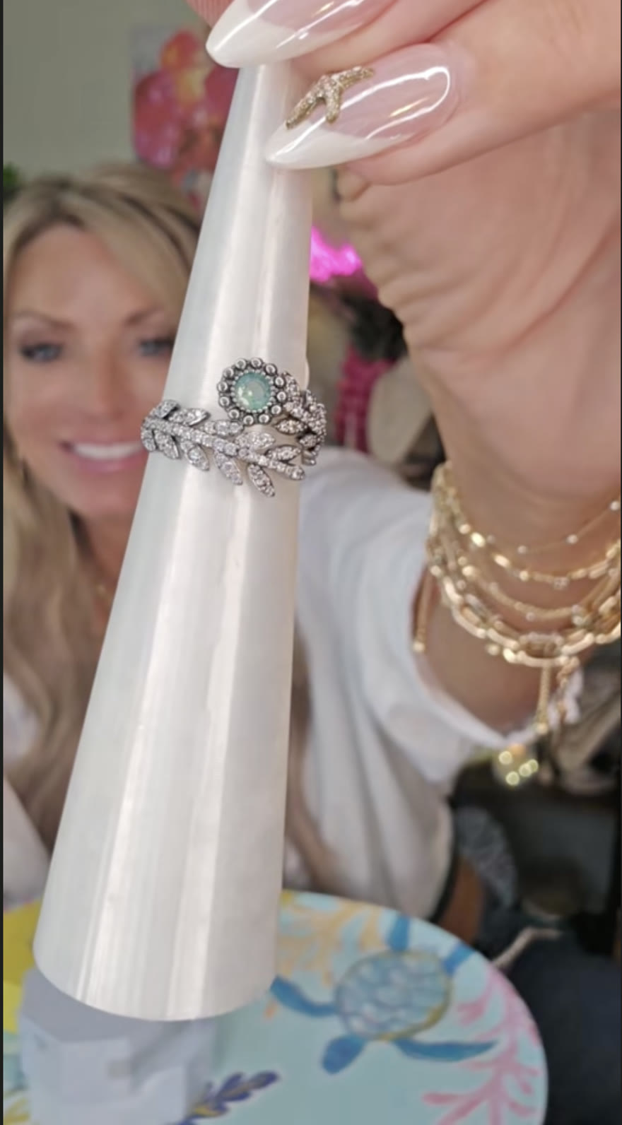 Tracy smiling behind a crystal leaf ring on a display cone